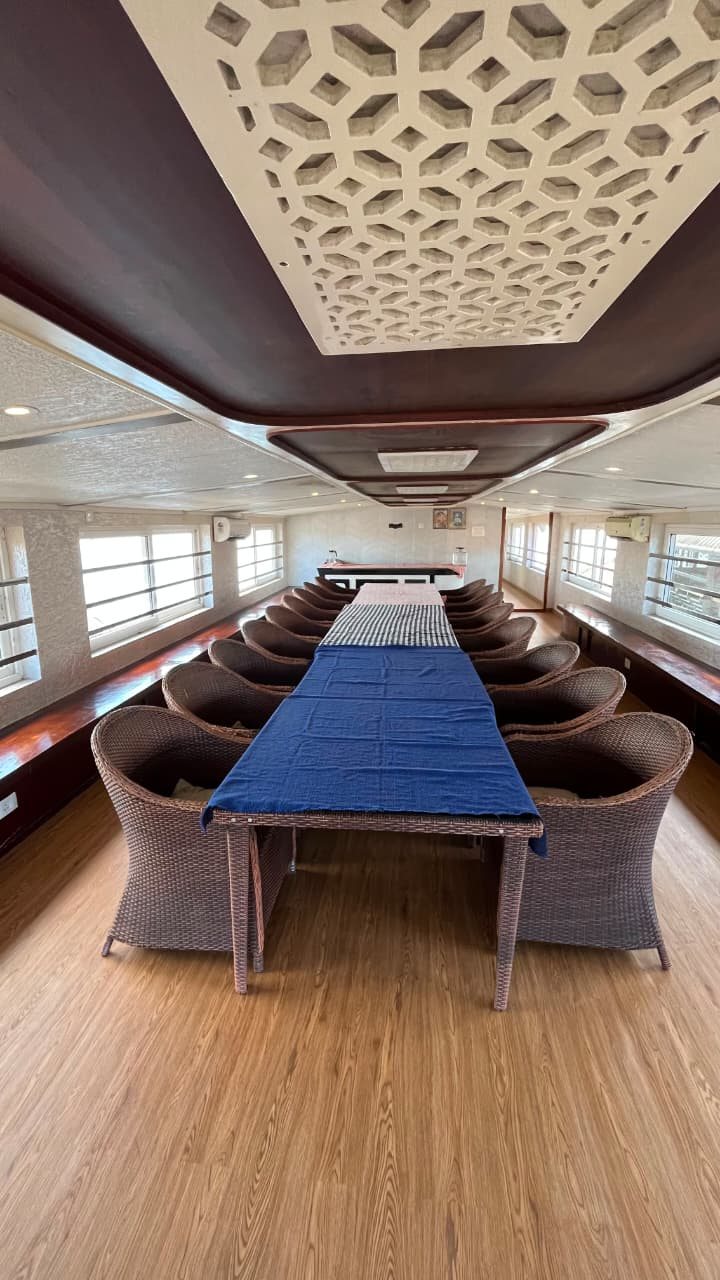 A long dining table with chairs in the premium houseboat